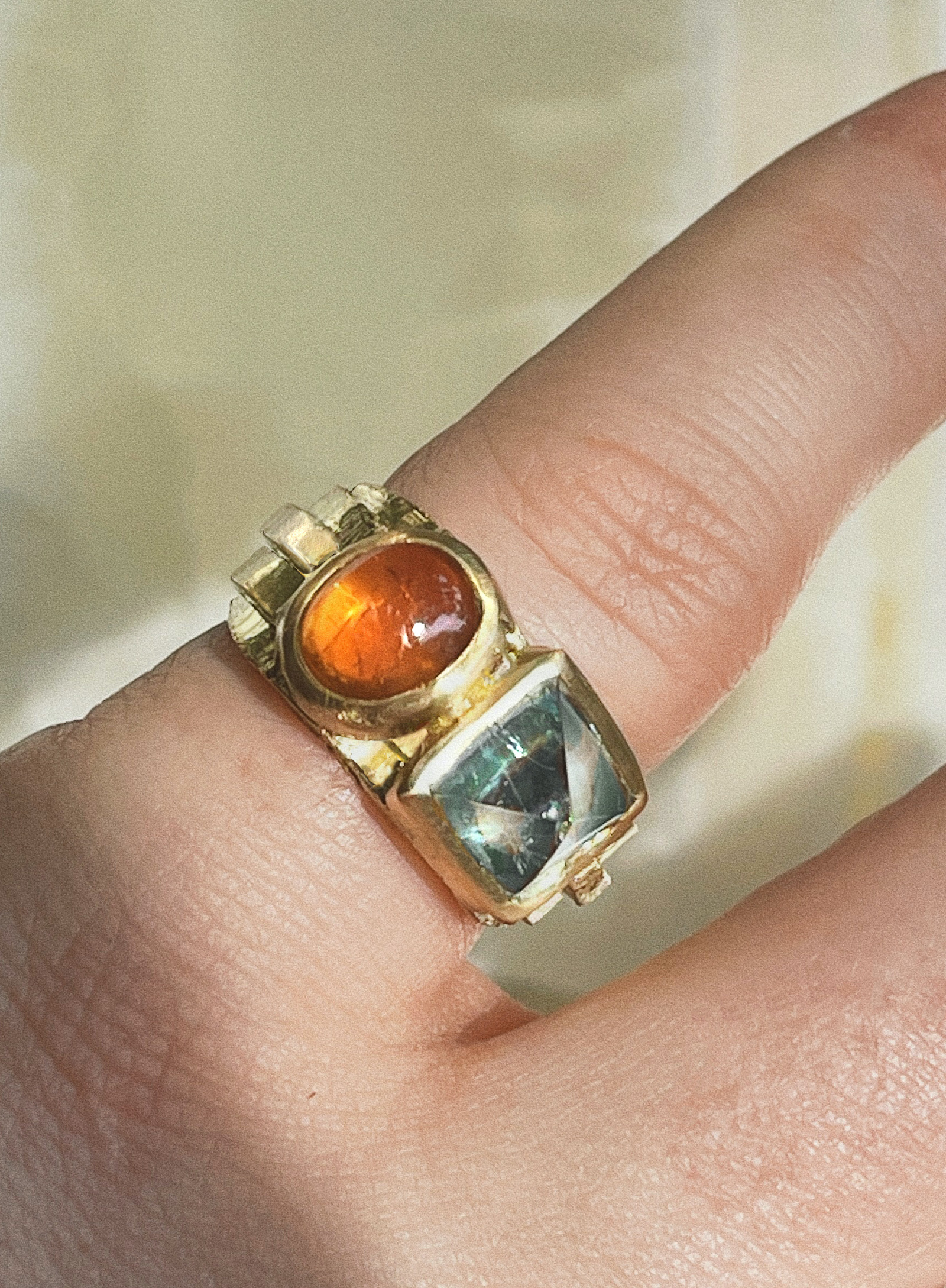 Oval Mandarin garnet and Sugarloaf Aquamarine in a gold ring with six "steps" going up and down.